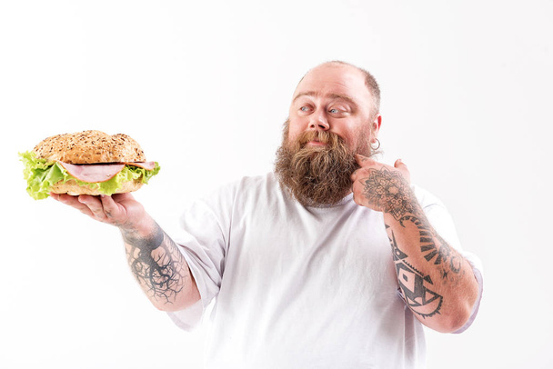 Happy fat man showing large burger - Foto, Imagem