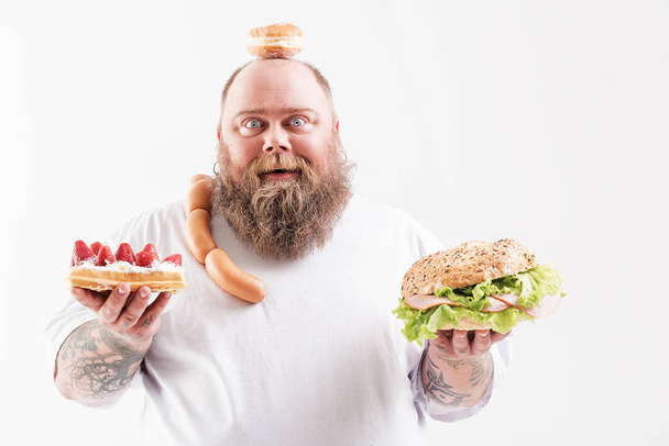 Joyful fat man prefers unhealthy eating - Foto, immagini