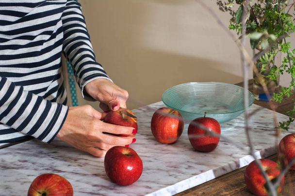 Woman cutting apples on the table - Фото, зображення