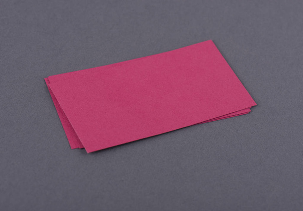 Burla de tarjetas de visita rojas pila de fans sobre fondo de papel texturizado negro
. - Foto, Imagen