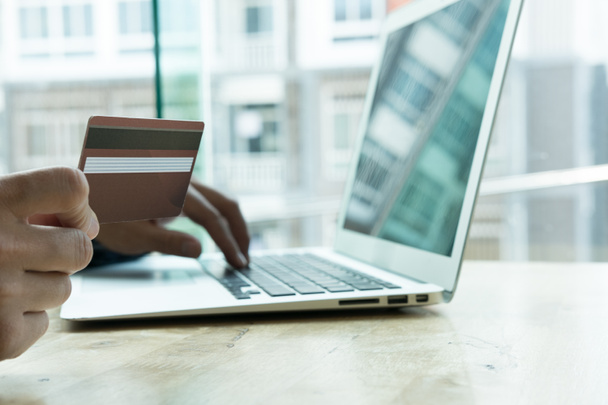 мужчина держит кредитную карту и с помощью ноутбука для онлайн
  - Фото, изображение