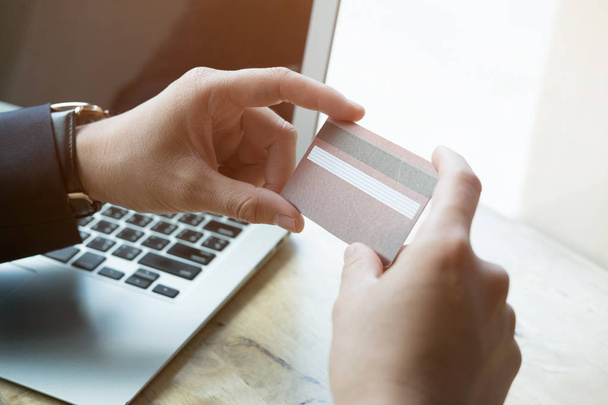 masculino segurando um cartão de crédito e usando computador portátil para on-line
  - Foto, Imagem