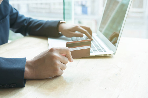 erkek bir kredi kartı tutan ve dizüstü bilgisayar için çevrimiçi kullanarak  - Fotoğraf, Görsel