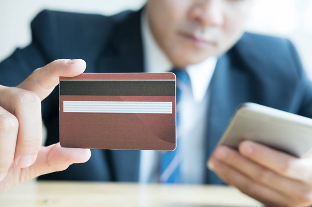 férfi gazdaság egy hitelkártya és okos mobiltelefon használata a onli - Fotó, kép