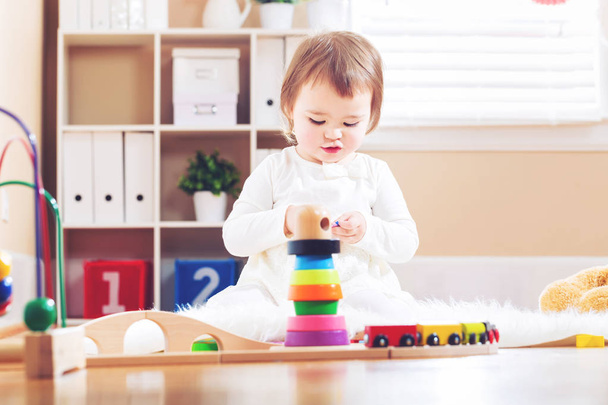 Счастливая девочка, играющая с игрушками
 - Фото, изображение