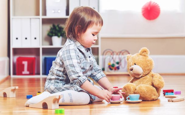 Happy toddler girl playing with her teddy bear - Foto, imagen