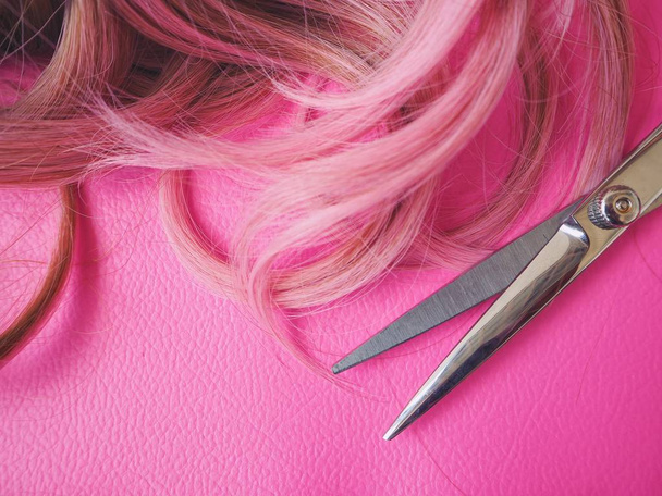 Tijeras para cortar el cabello sobre fondo rosa
 - Foto, imagen