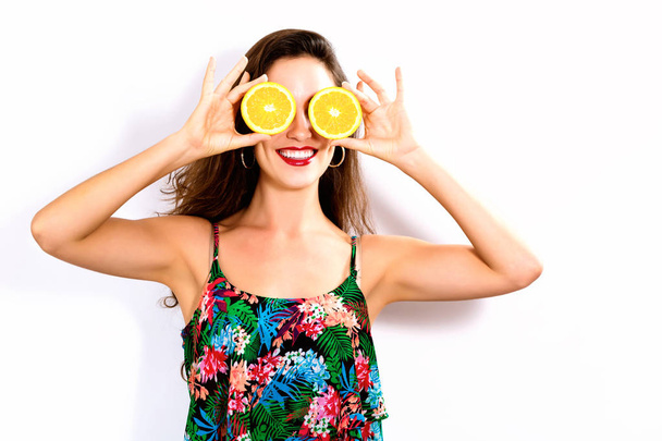 Happy young woman holding oranges halves - Zdjęcie, obraz