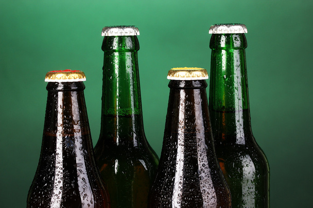 barevné skleněné lahve piva na zeleném pozadí - Fotografie, Obrázek