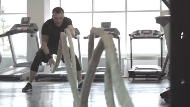 Slow motion van man met slag touw in functionele training fitness gym - Video