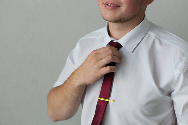 Empresario con camisa endereza su corbata roja
 - Foto, imagen