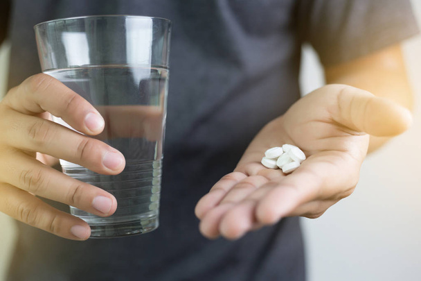 Mann Hand und Wasser Droge, Medizin, pflanzliches Präparat Pille, Eatin - Foto, Bild
