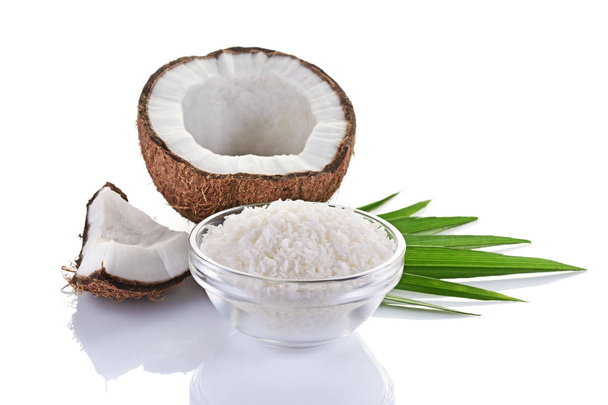 Healthy food. Fresh coconut with flakes in glass plate and green palm leaves - Photo, Image