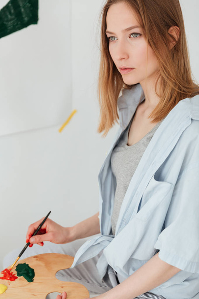 Concentrated young caucasian lady painter - 写真・画像