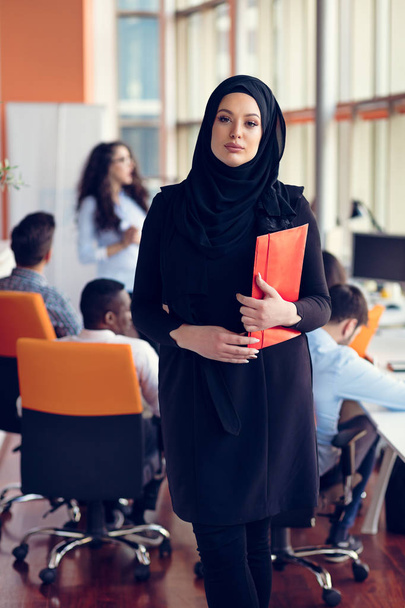 Арабская деловая женщина с хиджабом, держащая папку
 - Фото, изображение