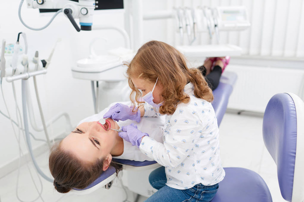 Little girl examining dentist in cabinet - Foto, Imagen