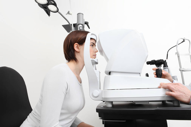 woman doing eyesight measurement with optician slit lamp - 写真・画像