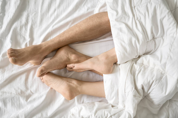 Legs of lovers under blanket - Fotografie, Obrázek