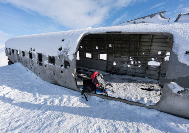 Rugzakken door vliegtuig wrak op sneeuw bedekt landschap - Foto, afbeelding