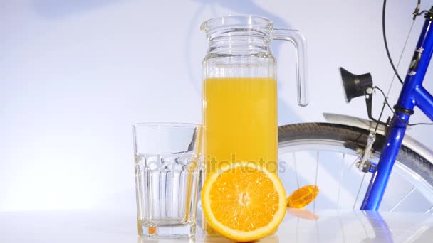 orange and orange juice rotation on the table bicyrcle on background - Video