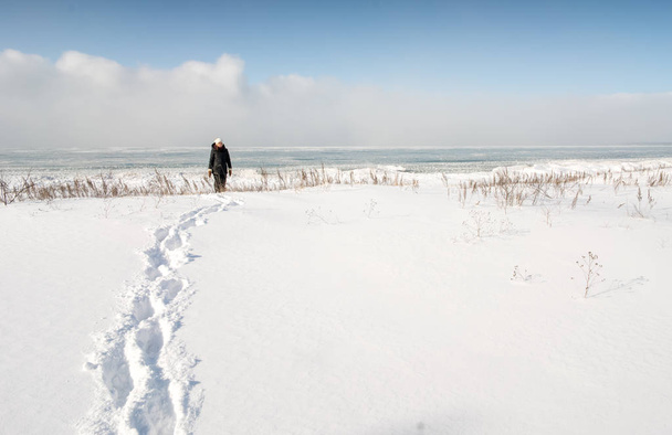 Wandelen in de sneeuw bedekt landschap pad vrouw - Foto, afbeelding