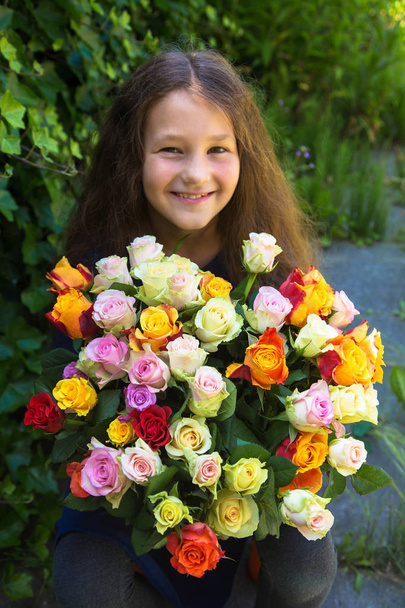 Αξιολάτρευτο κορίτσι έφηβος με μεγάλο μπουκέτο λουλούδια τριαντάφυλλα.  - Φωτογραφία, εικόνα