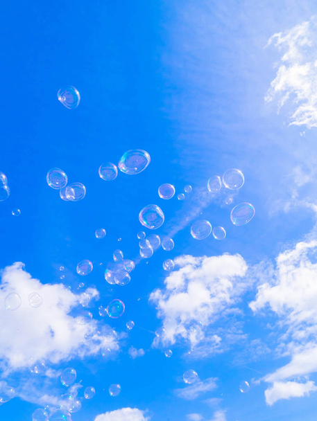 Блакитне небо і літаючі мильні бульбашки
 - Фото, зображення