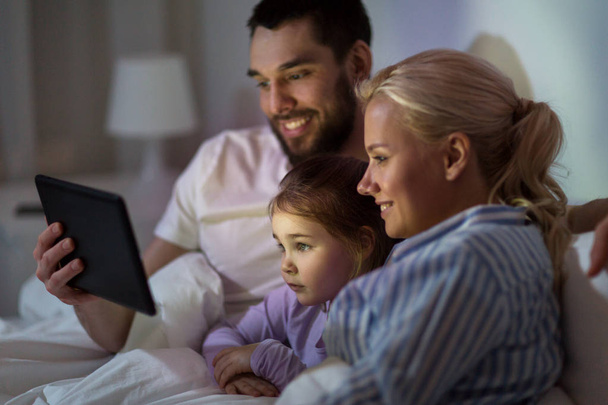 happy family with tablet pc in bed at home - Foto, imagen