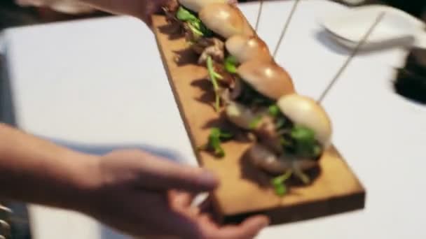 Camarero sirviendo mini hamburguesas en la fiesta
 - Imágenes, Vídeo