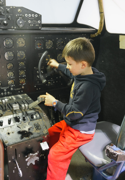 Jonge jongen in cockpit van stationaire vliegtuig  - Foto, afbeelding
