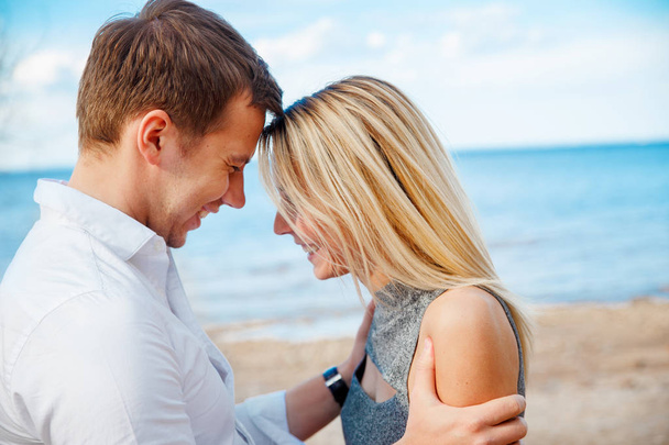 Romanttinen nuori pari seisoo päästä päähän rannalla
 - Valokuva, kuva