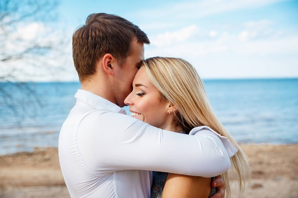 Romantic young couple standing head to head at beach - Фото, зображення