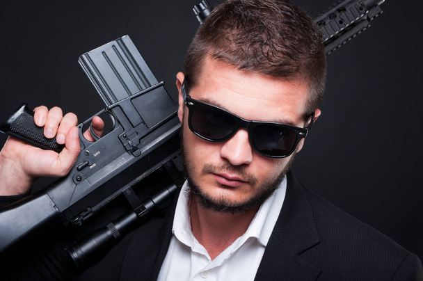 крупним планом портрет чоловічого гангстера з автоматичною зброєю
 - Фото, зображення