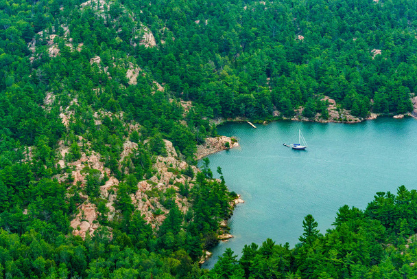 Bateau sur lac entouré de montagnes et d'arbres
 - Photo, image
