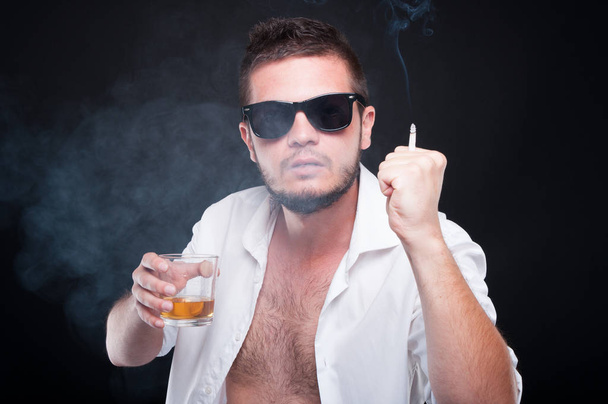 Agressieve jonge man gevechten terwijl het drinken van whisky - Foto, afbeelding
