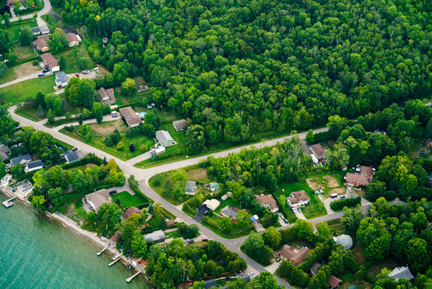 Luchtfoto van huizen in residentiële buitenwijken door lake - Foto, afbeelding