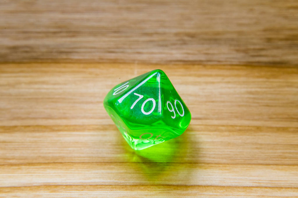 Um translúcido verde dez lados jogando dados em um backgroun de madeira
 - Foto, Imagem