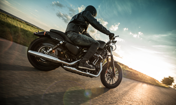 Чоловік катається на спортивних мотоциклах під час заходу сонця
. - Фото, зображення