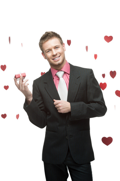 Young cheerful businessman holding red gift - Foto, immagini