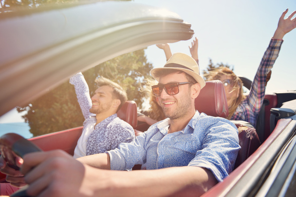 volný čas, výlet, cestování a lidé koncept - happy přátelé v kabriolet auto po venkovské silnici - Fotografie, Obrázek