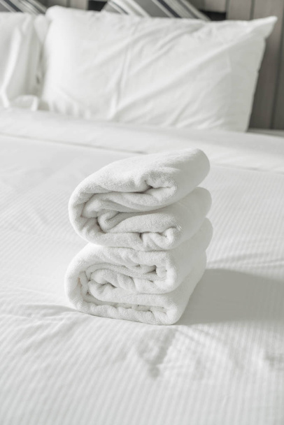 Toalla blanca en la decoración de la cama en el interior del dormitorio
  - Foto, imagen