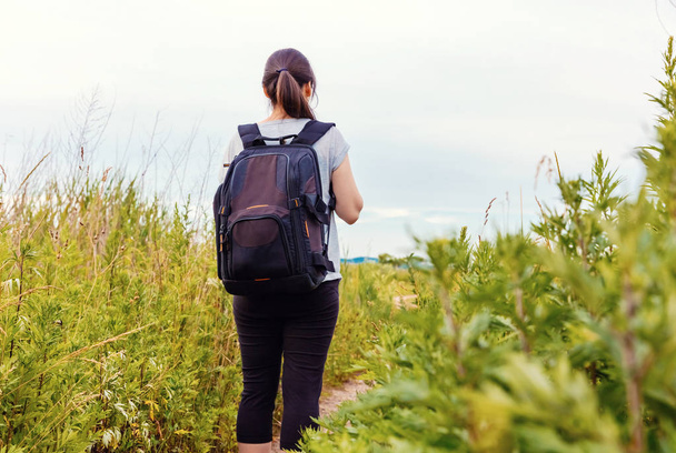 Woman with a backpack walking down a trail - Foto, Imagem