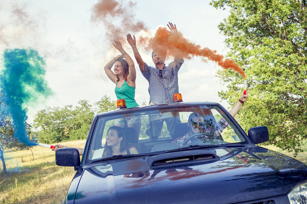 Group of young guys have fun with colored smoke trails - Foto, imagen