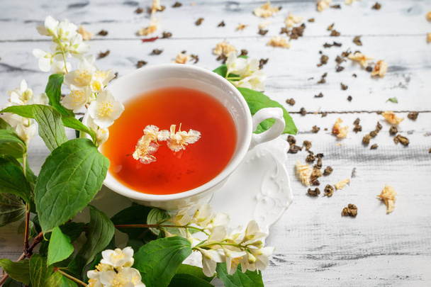 Csésze tea jázmin virágok fehér asztal - Fotó, kép