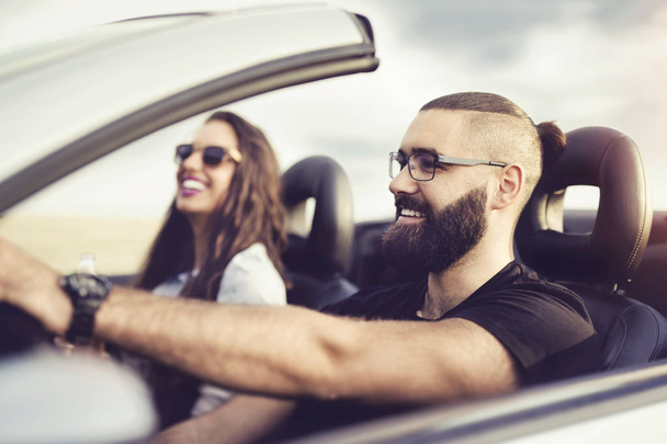 Freedom of the open road.Young Couple Driving Along Country Road In Open Top Car. - Fotografie, Obrázek
