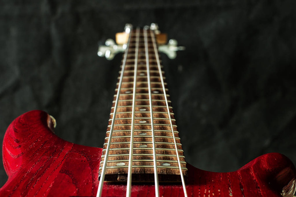 暗い背景に 4 つの文字列赤ベース ・ ギター - 写真・画像