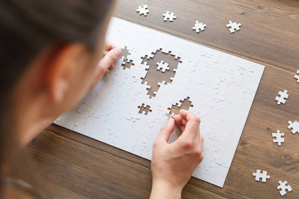Image of businesswoman connecting elements of white puzzle  - 写真・画像