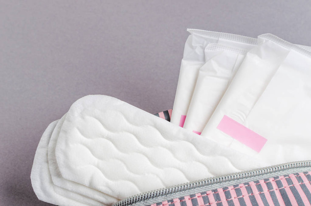 Assorbenti mestruali e pastiglie in sacchetto cosmetico. Ora delle mestruazioni. Igiene e protezione
 - Foto, immagini
