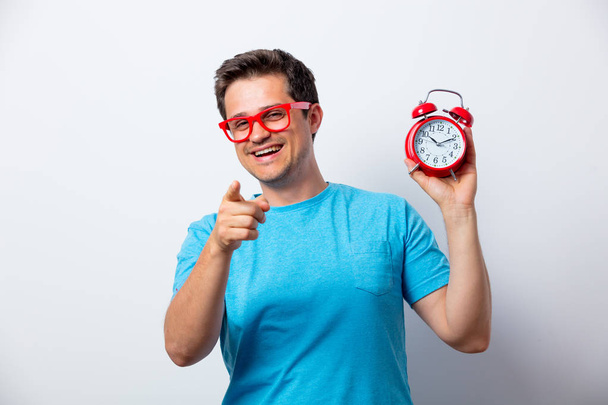 designer em óculos vermelhos com despertador
 - Foto, Imagem