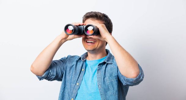 Young man seeking with binocular something  - Fotografie, Obrázek